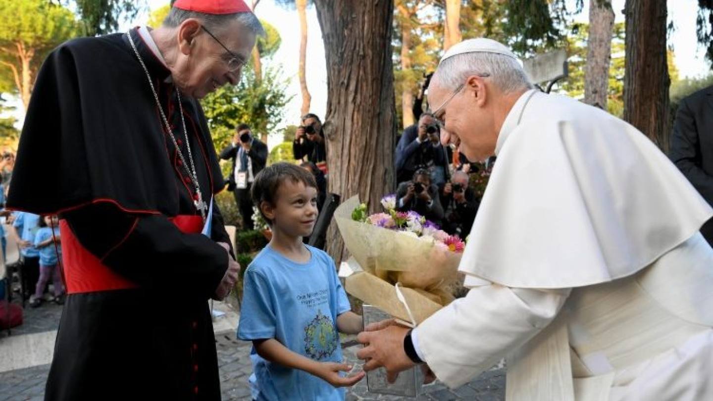 Foto Pope Leo and Cardinal Kurt Koch with a child at launch of Rosary campaign (© Vatican Media)