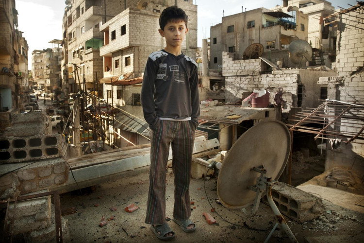 MO-ACN Foto van een jongen in een verwoeste wijk in Allepo